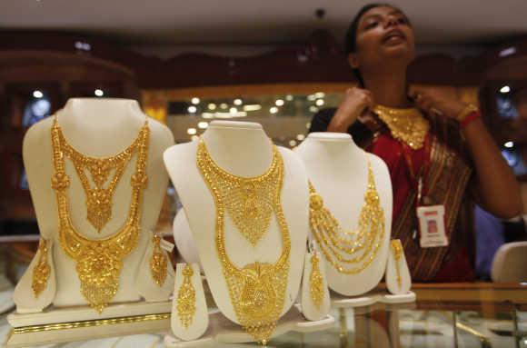 A saleswoman displays a gold necklace at a jewellery showroom in Kolkata.