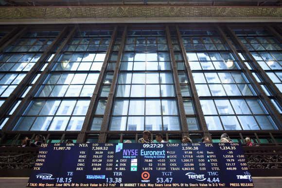 Visitors stand on a balcony overlooking the floor of the New York Stock Exchange in New York.