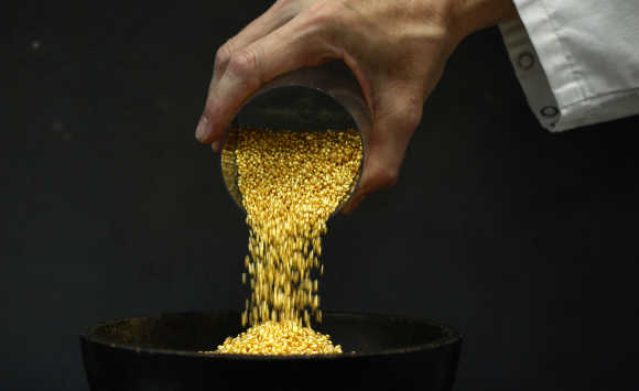 An employee empties a cup of gold granules at the Austrian Gold and Silver Separating Plant 'Oegussa' in Vienna.