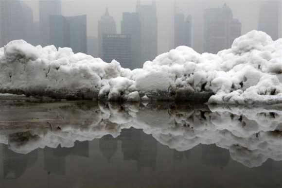 Shanghai's financial district is seen at the Bund promenade as snow falls in downtown.