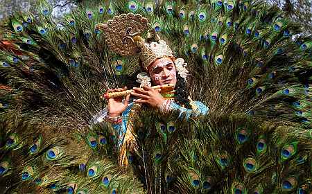 An artist dressed as Lord Krishna performs during a media preview of the 25th Surajkund Crafts Fair in the northern Indian state of Haryana