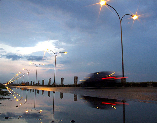 A car passes on a highway beneath pre-monsoon clouds in the eastern Indian city of Kolkata.
