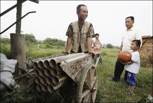 Chinese farmer Yang Youde pushes his homemade cannon near his farmland on the outskirts of Wuhan, Hubei province, China.