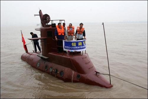 Chinese shipbuilders stand on a submarine designed by a farmer Li Yuming (not pictured) on the Yangtse River in Wuhan, central China's Hubei province.