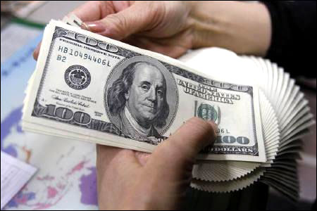 An employee of an money exchange counts US dollar bills in Tokyo.