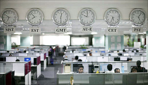 Workers are pictured beneath clocks displaying time zones in various parts of the world at an outsourcing centre in Bangalore.
