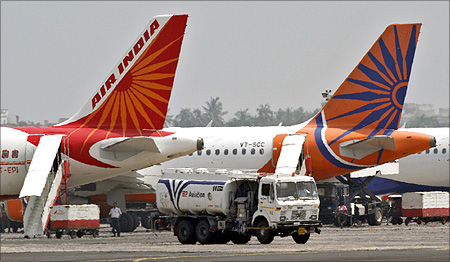 A fuel tanker moves past Air India passenger jets parked at an airport in Kolkata.