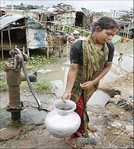 A woman carry drinking water from a village pump.