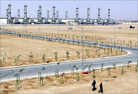 People walk near power plant number 10 at Saudi Electricity Company's Central Operation Area, south of Riyadh.