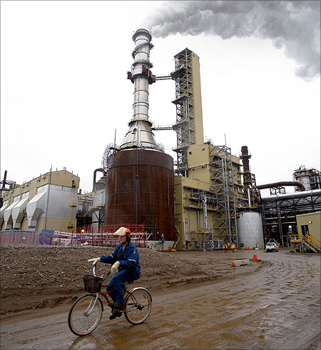 A worker rides his bike near Syncrude's $7.5 million expansion mine, which remains shut after residents complained of odors coming from the site, north of Fort McMurray, Alberta.