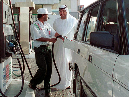 A car owner smiles as he chats to a petrol pump attendent while refilling his car at a Dubai petrol station.