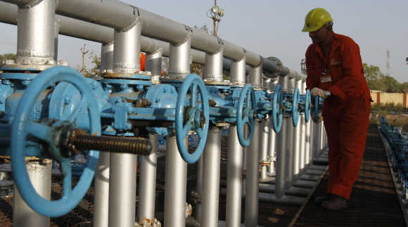 A technician opens a pressure gas valve inside ONGC group gathering station on the outskirts of Ahmedabad.