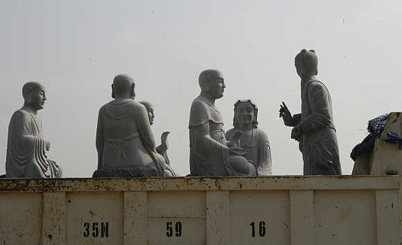 Stone statues of Buddhist arhats sit on a truck in Vietnam's northern Ninh Binh province.