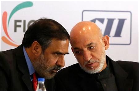 Afghanistan's President Hamid Karzai (R) speaks with Trade Minister Anand Sharma during a business conference in Mumbai November 10, 2012. Karzai is on a five-day state visit to India.