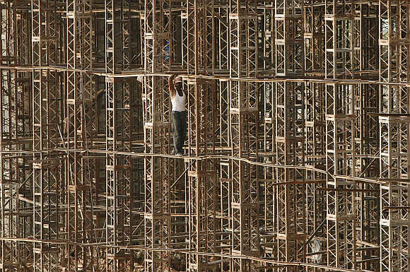A construction worker stands on scaffolding on the outskirts of Jammu.