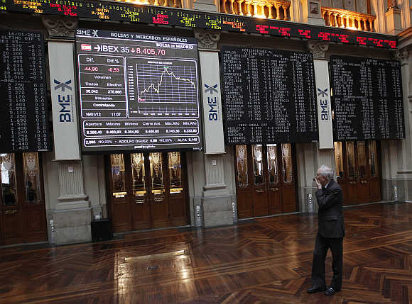 A trader looks at the stock index boards at Madrid's bourse.