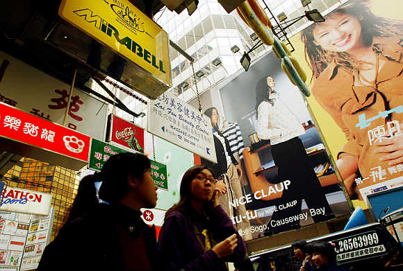 Shoppers are surrounded by advertisements at Hong Kong's Causeway Bay shopping district.