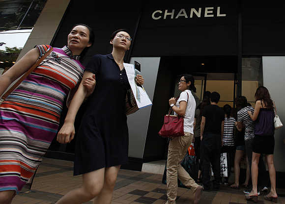 Mainland Chinese visitors walk past a Chanel store as others line up at Hong Kong's Tsim Sha Tsui district.