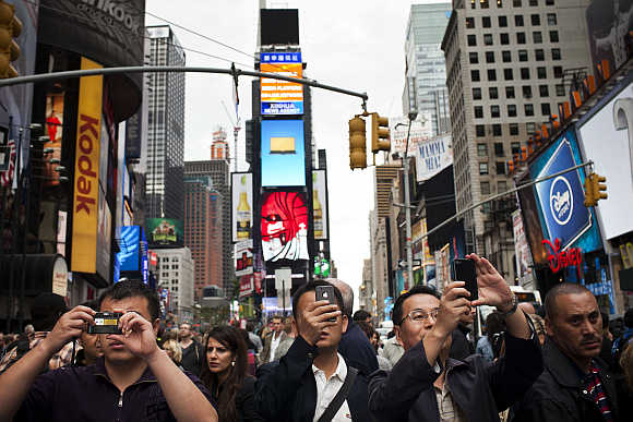 Tourists take photos in Times Square in New York.