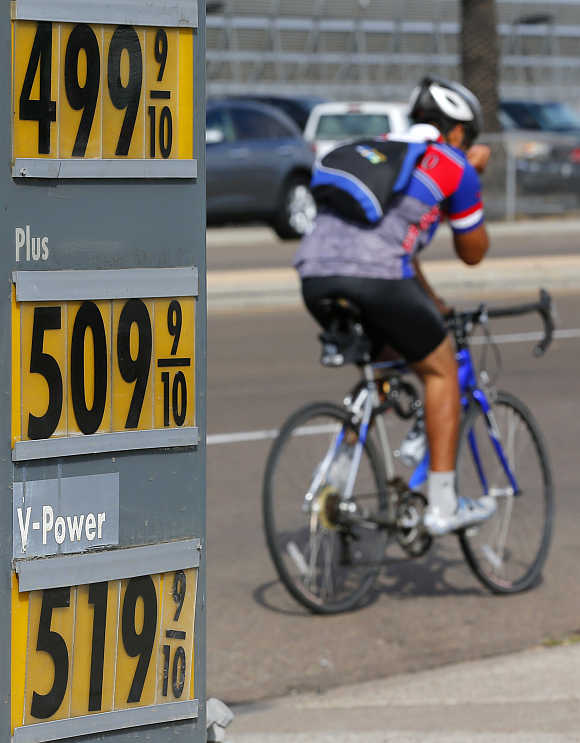 A cyclists rides past a gas station in San Diego, California.