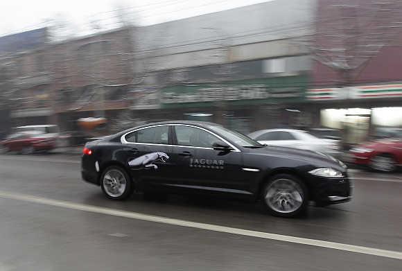 A Jaguar XF car is driven through the streets of Beijing.