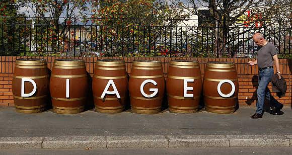 A man walks past barrels outside the Diageo Shieldhall facility near Glasgow, Scotland.