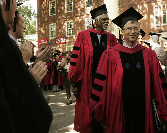 Honorary degree recipient Bill Gates walks past graduating students during Commencement Exercises at Harvard University in Cambridge.