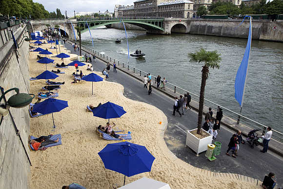People enjoy the sun as Paris Beach opens along banks of the River Seine.