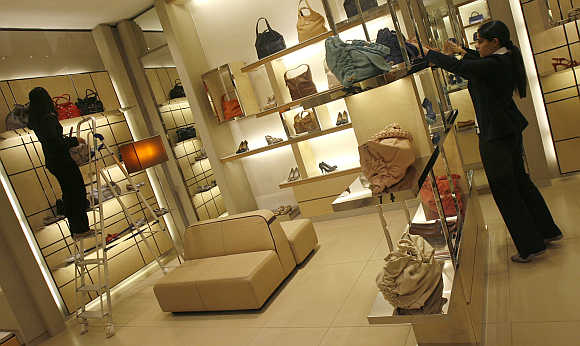 Employees adjust products inside their showroom at a mall in New Delhi.