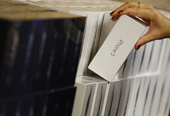 A store worker picks up an Apple iPhone 5 in London.
