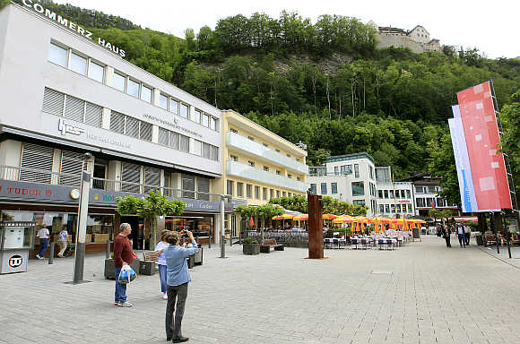 A woman takes a picture of Vaduz Castle in the town centre of Liechtenstein's capital Vaduz.