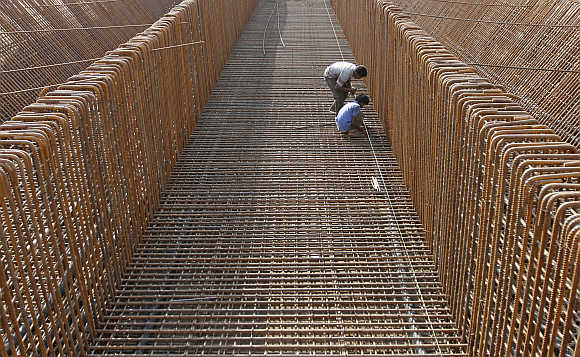 Labourers work at the construction site of a flyover on the outskirts of Ahmedabad.