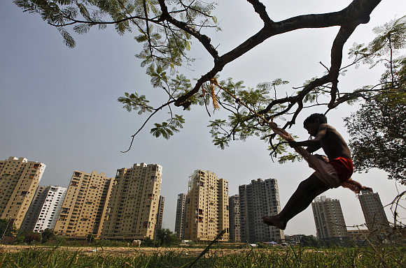 A boy plays on a swing in front of a residential estate in Kolkata.