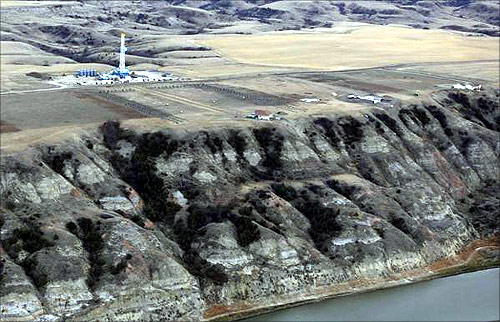 An oil drilling rig operates near homes, farm fields and the Missouri River outside Williston, North Dakota.
