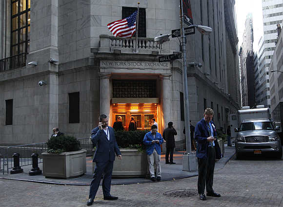 Traders stand outside the New York Stock Exchange prior to the opening bell.
