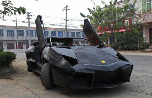 A friend of Wang Jian sits in a hand-made replica of a Lamborghini Reventon in Suqian, Jiangsu province, China. Wang, a young farmer who worked at a garage for more than a decade, built the replica of a Lamborghini Reventon with a second-hand Nissan and Santana. The self-made roadster cost Wang around 60,000 RMB ($9,450) and can reach a maximum speed of 160mph.