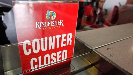 An employee of Kingfisher Airlines works next to a ''counter closed'' sign before the airline stopped operations.