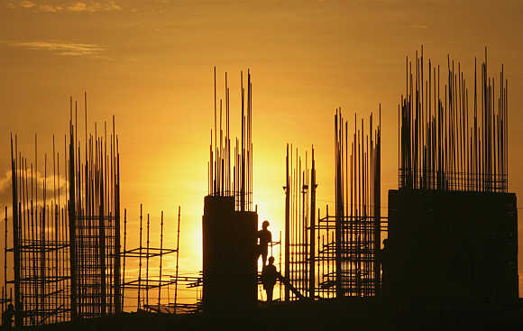 Labourers are silhouetted against the setting sun as they work at a construction site in Hyderabad.