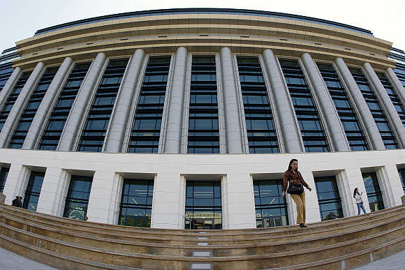A woman walks down the steps in front of National Library in Bucharest, Romania.
