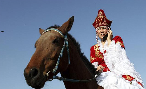 A woman speak on a mobile phone while attending an equestrian games festival in Bishkek.