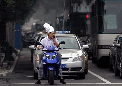 A motorist talks on his mobile phone as he waits at traffic lights in Beijing.