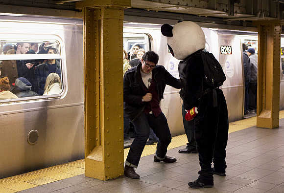 A man punches another man dressed up as 'Punch Me Panda' inside the subway system in New York City.