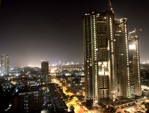A high-rise building is lit up during construction in Mumbai.