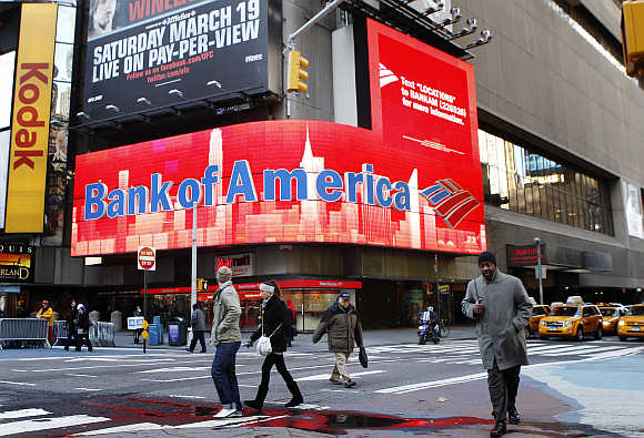 Pedestrians walk past a Bank of America sign on a building in Times Square in New York.