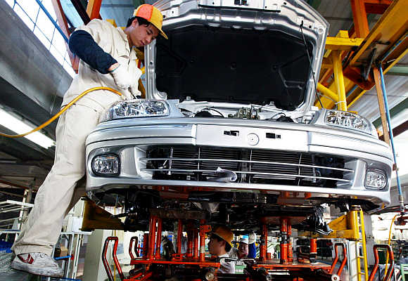 Chinese workers assemble a Nissan Sunny car in Guangzhou, Guangdong province.