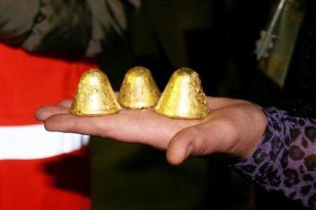A GV Gold worker holds out gold dore nuggets produced at the Golets Vysochaishy mine in eastern Siberia.