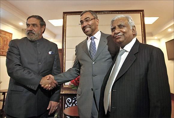 Trade Minister Anand Sharma shakes hands with Ahmed Ali-al-Sayegh, a board member of Abu Dhabi's Etihad Airways, as Jet Airways Chairman Naresh Goyal (L-R) looks on.