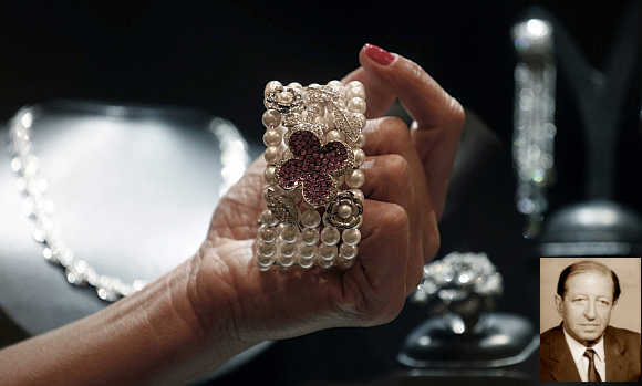 A shop assistant shows a bracelet from Brazilian designer Mauricio Monteiro, containing a selection of large pink sapphires, pearls and diamonds, at the Iguatemi mall in Sao Paulo, Brazil. Inset, Robert Fayez Mouawad.