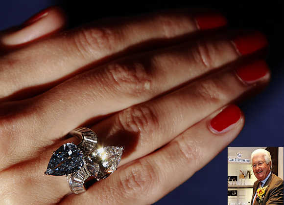 A Bonhams employee poses with the Bvlgari crossover ring set with 3.72 carat fancy vivid blue diamond and 3.93 carat diamond at Bonhams auction house in London. Inset, Jorg Bucherer.