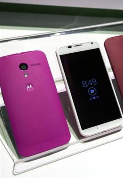 Different colored examples of Motorola's new Moto X phones rest on a table at a launch event in New York.